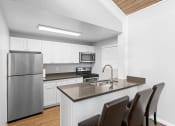 Thumbnail 3 of 22 - a kitchen with a island and a stainless steel refrigerator