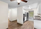 Thumbnail 5 of 22 - a renovated kitchen with white cabinets and a black refrigerator