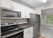 Thumbnail 1 of 22 - a kitchen with stainless steel appliances and white cabinets