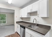 Thumbnail 2 of 22 - an empty kitchen with white cabinets and a sink