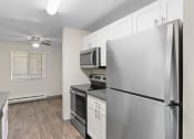 Thumbnail 4 of 22 - an empty kitchen with stainless steel appliances and a ceiling fan
