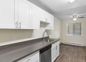 Thumbnail 6 of 22 - an empty kitchen with white cabinets and a sink
