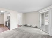 Thumbnail 7 of 22 - an empty living room with sliding glass doors to a kitchen
