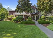 Thumbnail 21 of 26 - a house with a sidewalk in front of a lawn and trees
