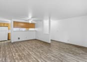 Thumbnail 6 of 26 - an empty living room with wood flooring and a kitchen