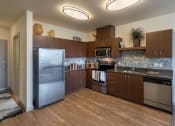 Thumbnail 14 of 20 - a kitchen with wooden cabinets and stainless steel appliances