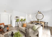 Thumbnail 1 of 25 - A living room with a white couch and a green plant on the coffee table.