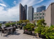 Thumbnail 1 of 20 - a roof deck with tables and chairs and a view of the city