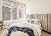 Thumbnail 10 of 20 - a bedroom with a bed and a large window