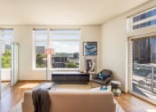 Thumbnail 14 of 20 - a living room with a couch and a chair in front of a window with a view of