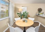 Thumbnail 11 of 26 - a dining room with a table and chairs and a window