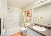 Thumbnail 23 of 30 - A white toilet sits in a bathroom next to a sink.