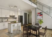 Thumbnail 12 of 22 - an open kitchen and dining area with a staircase in the background