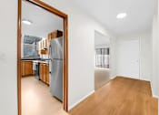 Thumbnail 12 of 41 - A kitchen with a refrigerator and wooden cabinets is visible through a mirror.