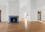 Thumbnail 16 of 41 - A modern living room with a fireplace and hardwood floors.