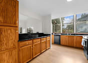 Thumbnail 3 of 41 - A kitchen with wooden cabinets and black countertops.