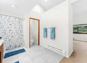 Thumbnail 24 of 41 - A bathroom with a blue and white shower curtain.