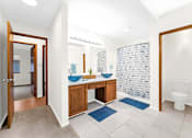 Thumbnail 23 of 41 - A bathroom with a toilet, sink, and mirror.