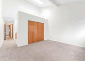 Thumbnail 21 of 41 - A room with a brown door and a white wall.