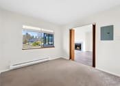 Thumbnail 22 of 41 - A room with a window, a door, and a wall socket.