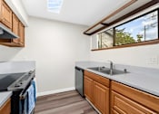 Thumbnail 9 of 41 - A kitchen with wooden cabinets and a skylight.