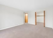 Thumbnail 26 of 41 - A room with a white wall and a brown door.