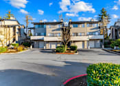 Thumbnail 32 of 41 - A large building with a parking lot in front of it.
