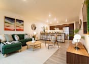 Thumbnail 13 of 34 - A living room with a green couch and a coffee table.
