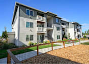 Thumbnail 26 of 34 - A modern apartment building with a fenced front yard.