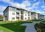 Thumbnail 3 of 34 - Apartment complex with a walkway in front.