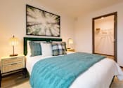 Thumbnail 5 of 34 - A bedroom with a large bed and a painting on the wall.
