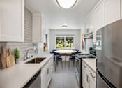 Thumbnail 2 of 29 - A modern kitchen with a large island and stainless steel appliances.