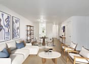 Thumbnail 5 of 29 - A living room with a white couch and a coffee table.