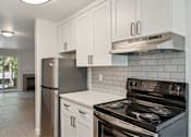 Thumbnail 8 of 29 - A modern kitchen with a stove and refrigerator.