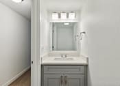 Thumbnail 17 of 29 - A bathroom with a sink, mirror, and lights.