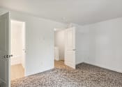 Thumbnail 18 of 29 - A room with white walls and a carpeted floor with two doors.