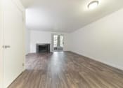 Thumbnail 19 of 29 - A room with wooden floors and a fireplace.