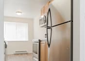 Thumbnail 21 of 29 - A modern kitchen with a refrigerator, oven, and microwave.