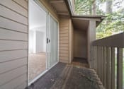 Thumbnail 27 of 29 - A deck with a sliding glass door leading to a room.