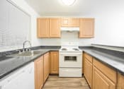 Thumbnail 23 of 29 - A kitchen with wooden cabinets and a white stove top oven.