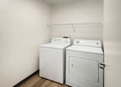 Thumbnail 34 of 34 - an empty laundry room with two washes and a dryer