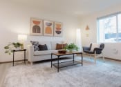 Thumbnail 1 of 18 - a living room with a couch and a table and a window