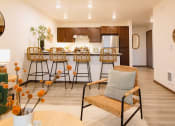 Thumbnail 17 of 18 - a living room with a bar and a kitchen with stools