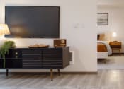 Thumbnail 3 of 24 - a living room with a tv and a bedroom in the background