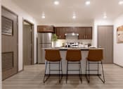 Thumbnail 7 of 18 - a kitchen with a island with three stools in front of it