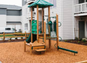 Thumbnail 8 of 18 - a playground with a swing set in front of an apartment building