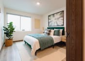 Thumbnail 4 of 24 - a bedroom with a bed and a potted plant