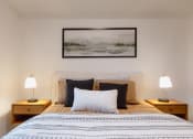 Thumbnail 5 of 24 - a bedroom with a bed with pillows and a picture on the wall