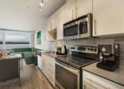 Thumbnail 6 of 22 - a kitchen with white cabinets and stainless steel appliances