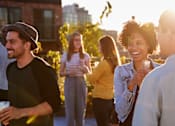 Thumbnail 4 of 8 - A group of people are standing outside on a sunny day.